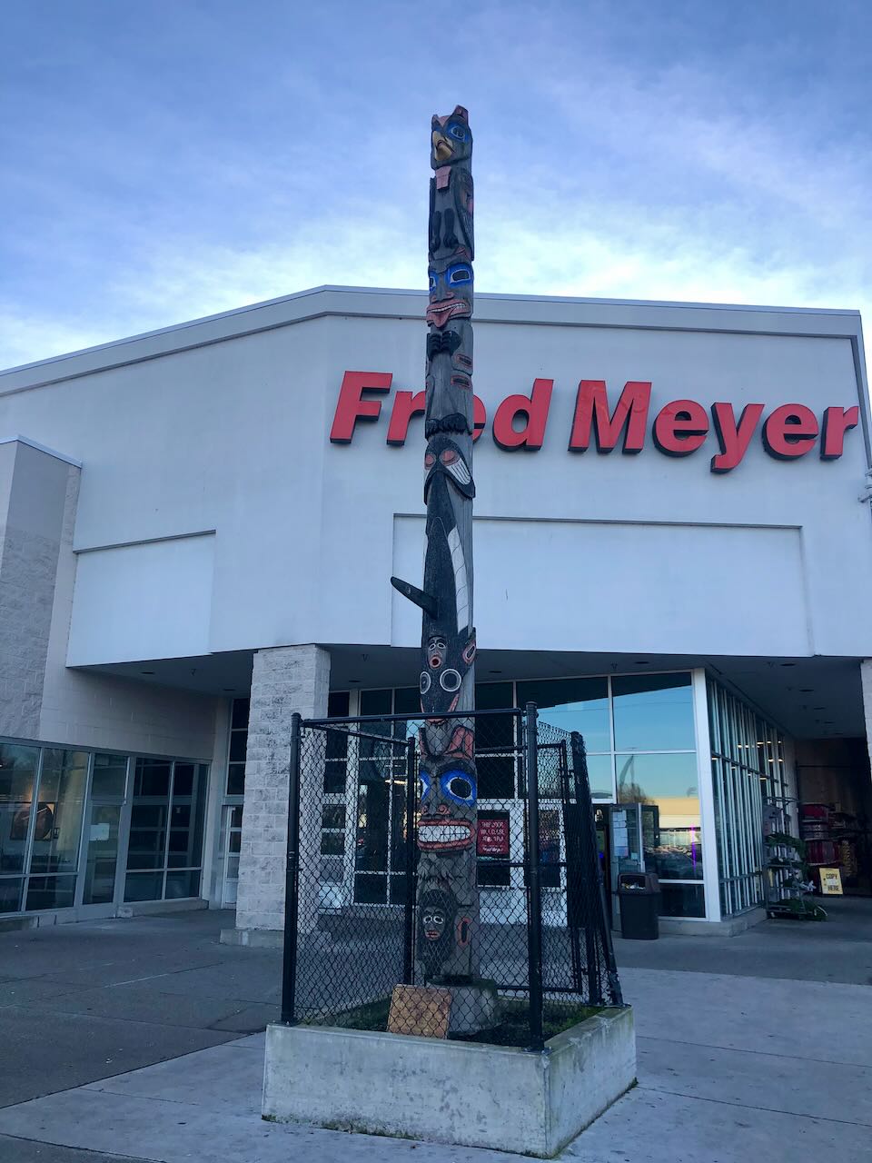 Wooden totem pole standing outside the entrance to a Fred Meyer store
