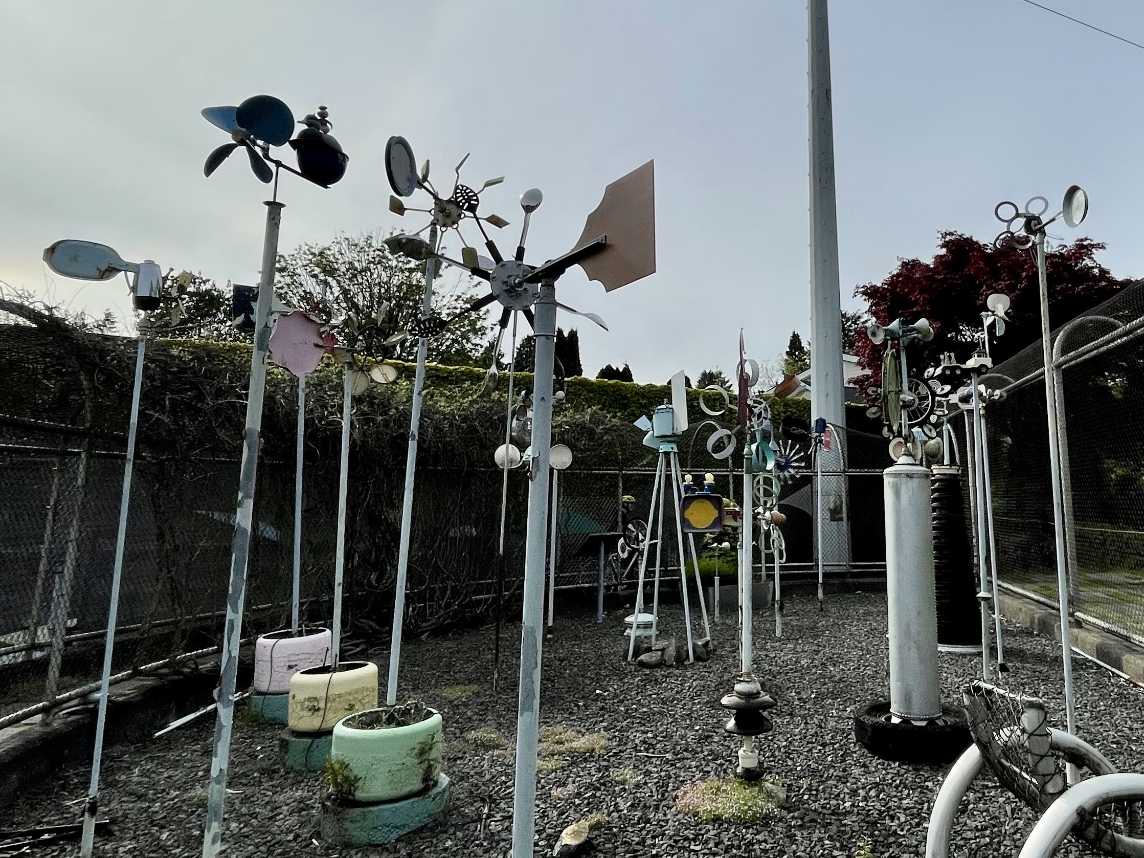 arrangement of metal wind sculptures made out of various household items
