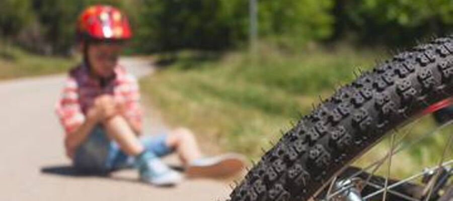 Kid on ground after falling off bike