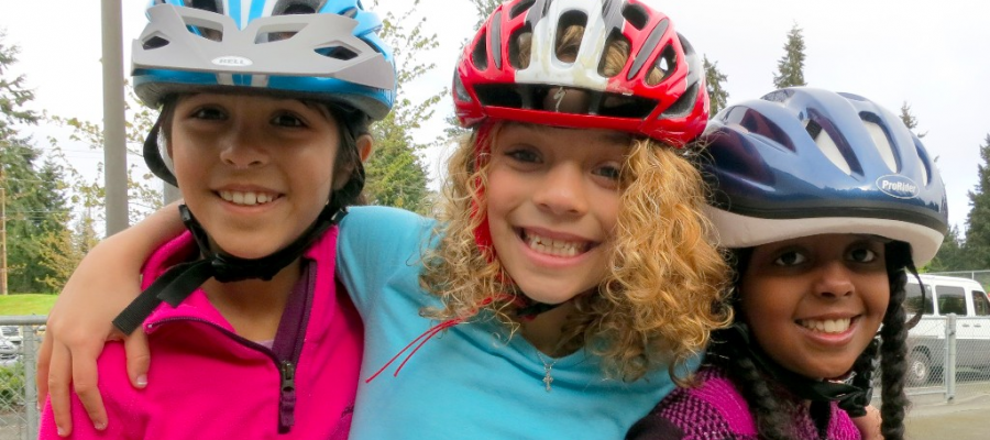 Let's Go brings the bicycles, these kids bring the smiles. YOU make it happen! Three girls with their new bike helmets