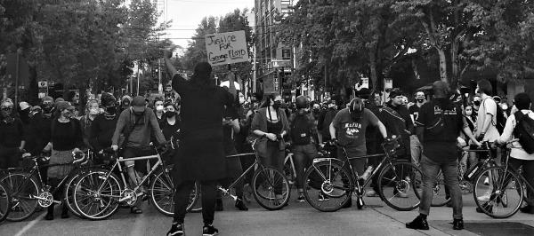 Bikes lined up in front of people protesting the police