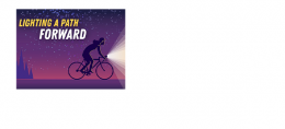 A bicyclist rides at night with an illuminated bike light under the banner Lighting a Path Forward